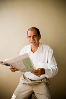 Portrait of a mature man holding a newspaper and smiling