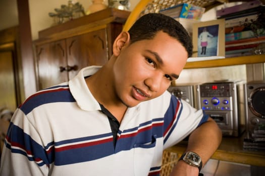 Portrait of a young man leaning against a shelf
