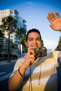 Close-up of a mid adult man holding a camera, Malecon, Santo Domingo, Dominican Republic