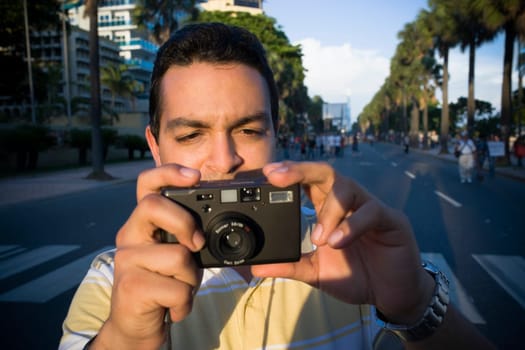 Close-up of a mid adult man holding a camera, Malecon, Santo Domingo, Dominican Republic