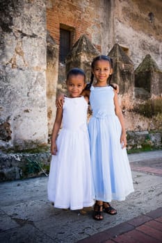 Portrait of two girls smiling and standing together with their arms around each other, Santo Domingo, Dominican Republic