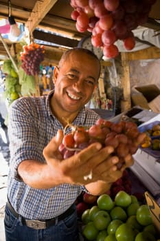 Portrait of a mature man holding a bunch of red grapes, Santo Domingo, Dominican Republic