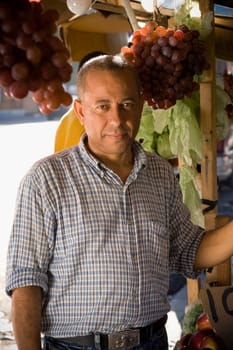 Portrait of a mature man in front of a market stall, Santo Domingo, Dominican Republic