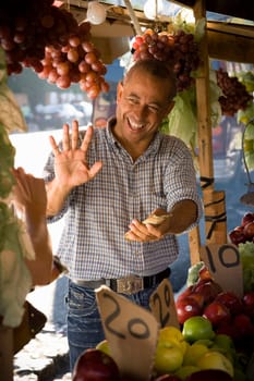 Fruit seller holding money and gesturing, Santo Domingo, Dominican Republic