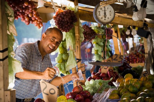 Portrait of a fruit seller splashing water over fruits at a market stall, Santo Domingo, Dominican Republic