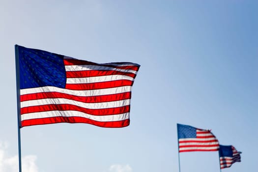 Three American flags fluttering in the sky
