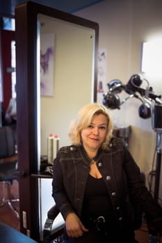 Shop owner sits in salon chair