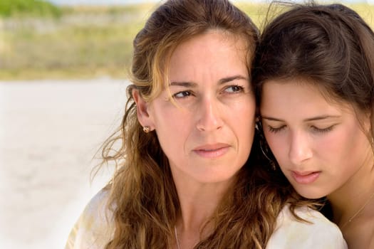 Two women sitting side by side at beach