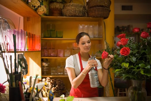 Young woman in flower shop with rose arrangement