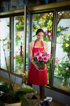 Flower shop owner holding arrangement
