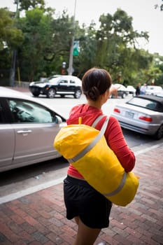 Young woman walking with duffel bag