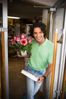 Flower shop delivery person leaving store with arrangement