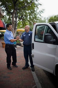 Two servicemen greet each other outdoors