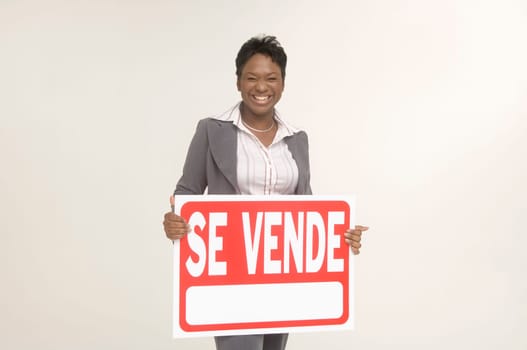 Real Estate agent holding a For Sale (Se Vende) sign