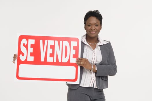 Real Estate agent holding a For Sale (Se Vende) sign