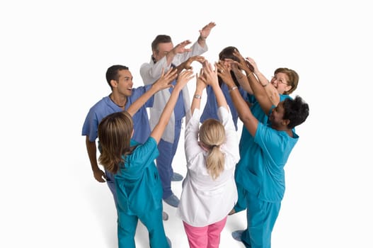 Group portrait of nurses and doctors cheering in circle
