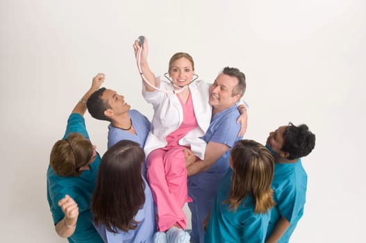 Group portrait of nurses carrying doctor