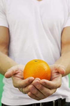Young man holding an orange