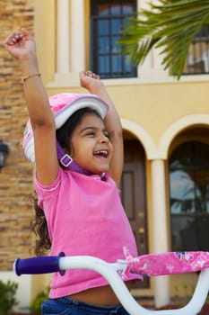 Close-up of a girl laughing with her arms raised