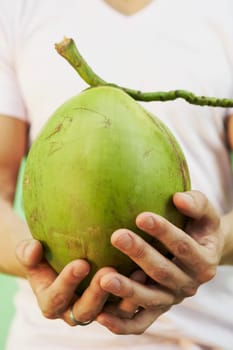 Young man holding a coconut