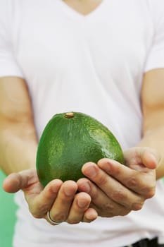 Young man holding an avocado