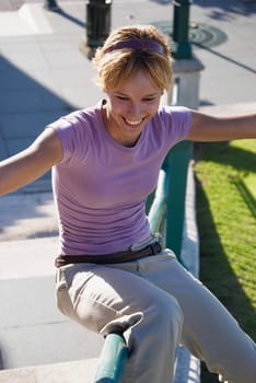 Young woman sitting on railing