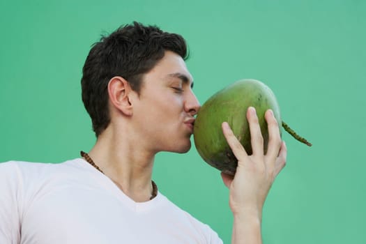 Young man kissing coconut
