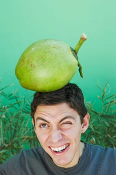Young man balancing coconut