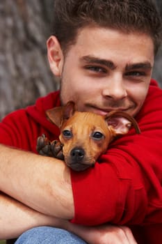 Portrait of a young man hugging his pet