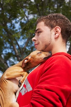 Side profile of a young man with a dog