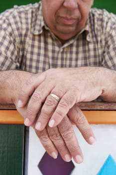 Close-up of a senior man leaning on a railing