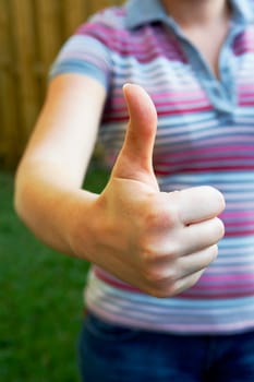 Mid section view of a woman making a thumbs up sign