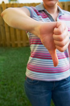 Mid section view of a woman making a thumbs down sign
