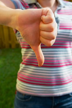 Mid section view of a woman making a thumbs down sign