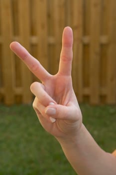 Close-up of a woman's hand making a peace sign