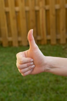Close-up of a woman's hand making a thumbs up sign