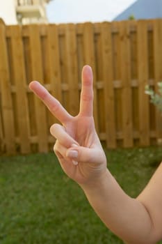 Close-up of a woman's hand making a peace sign