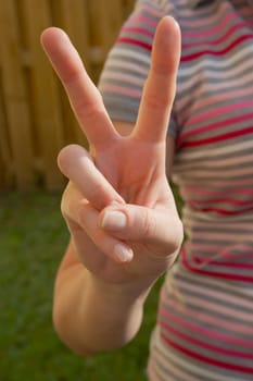 Mid section view of a woman making a peace sign