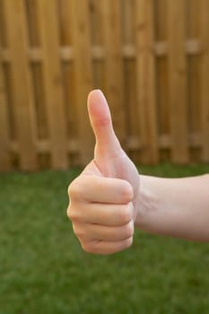 Close-up of a woman's hand making a thumbs up sign