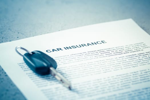 Concept of car insurance - car policy with car keys on blue tone