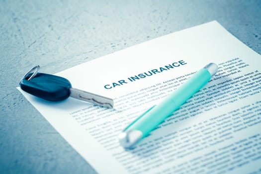 Concept of car insurance - car policy with car keys on blue tone