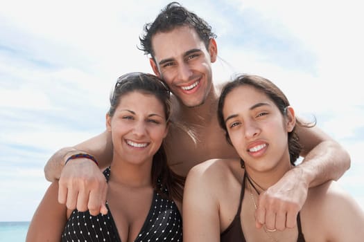 Portrait of two young women and a young man smiling