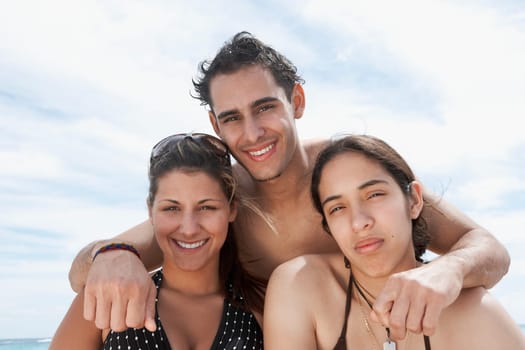 Portrait of two young women and a young man smiling
