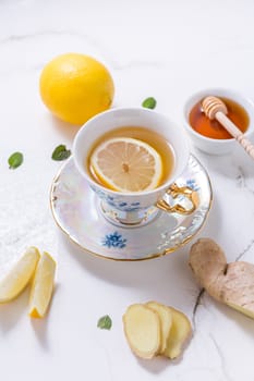 Tea with lemon, ginger and honey as natural medicine on white background