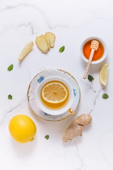 Tea with lemon, ginger and honey as natural medicine on white background