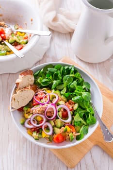 Tuna salad with cucumber, red onion, corn salad, cherry tomatoes and spices. Home made food. Concept for a tasty and healthy meal