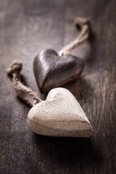 Black and white: two wooden hearts on wooden background
