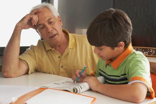 Senior man helping his grandson in his homework