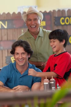 Portrait of a mid adult man smiling with his father and son in a restaurant