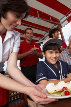 Boy celebrating his birthday with his grandfather in a restaurant